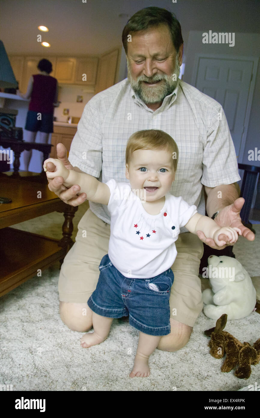 7 mois, fille, très fière d'elle-même pour l'article tout en accrochant sur  les mains de son grand-père Photo Stock - Alamy