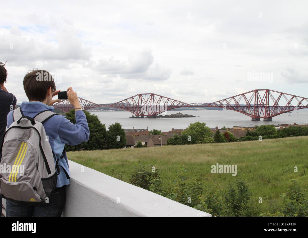 Edimbourg, Ecosse. 6 juillet, 2015. Un touriste prend des photos du Pont du Forth à South Queensferry au Firth of Forth, Ecosse, le 6 juillet 2015. Le Pont du Forth en Écosse au nord de la Grande-Bretagne a été officiellement inscrit comme une Organisation des Nations Unies pour l'éducation, la science et la culture (UNESCO) site du patrimoine mondial, il a été annoncé le dimanche. Credit : Guo Chunju/Xinhua/Alamy Live News Banque D'Images