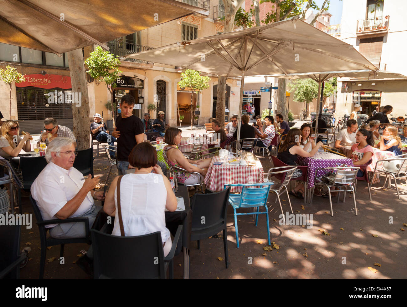 Les personnes mangeant à l'extérieur à un bar à tapas cafe, quartier de Gracia, Barcelone Espagne Europe Banque D'Images