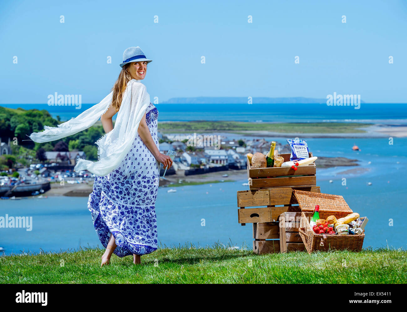 Une belle jeune femme avec champagne et un panier de pique-nique à l'autre côté sur l'Appledore Côte Nord du Devon Banque D'Images
