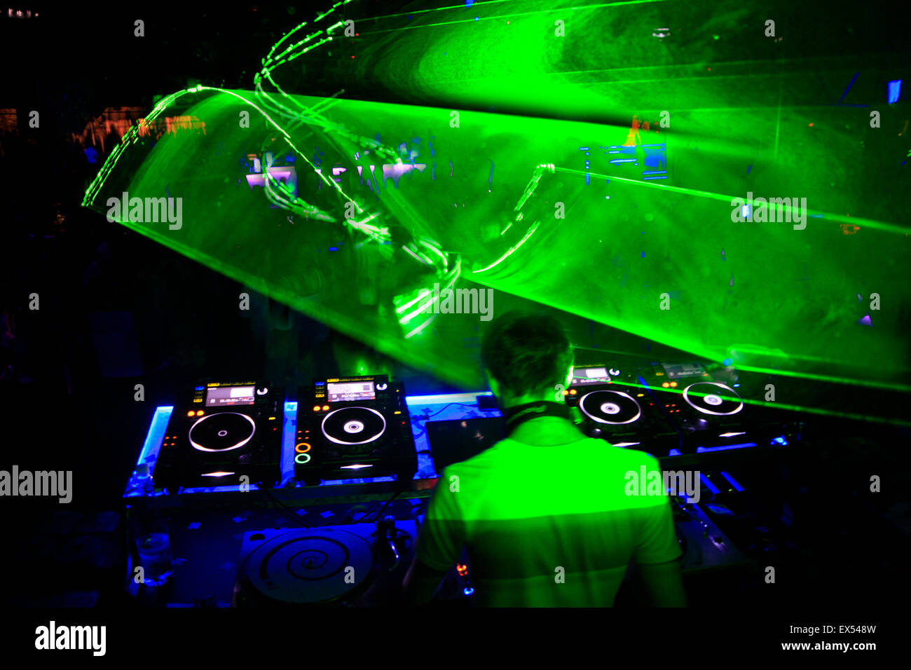 Image flou ambiant atmosphérique d'un spectacle laser lazer pattern graphiques projetés dans l'espace et DJ sur le pont dans une discothèque. Athènes, Grèce. Banque D'Images
