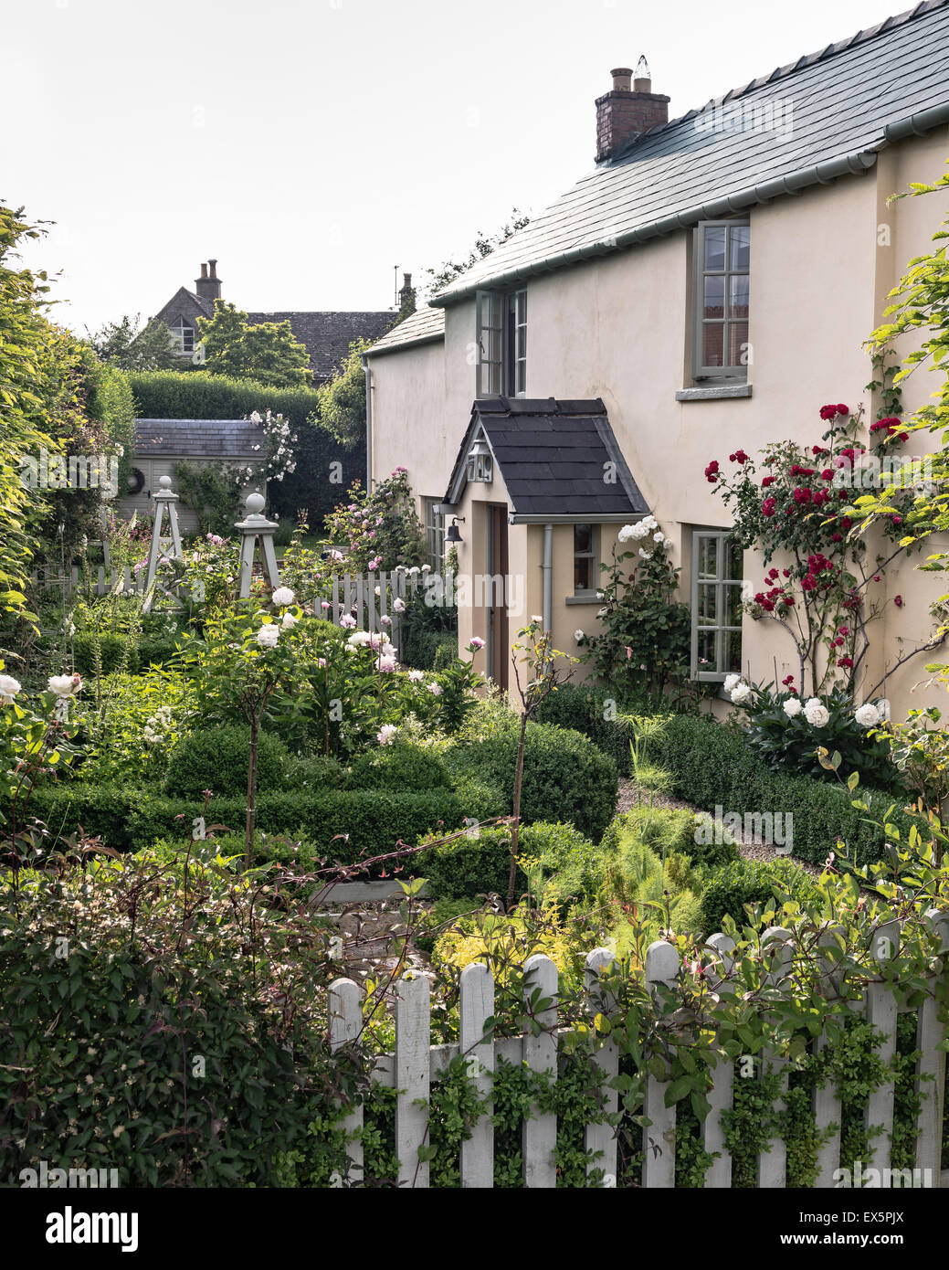 La façade extérieure d'une maison de campagne anglaise avec picket fence et Rose Garden Banque D'Images