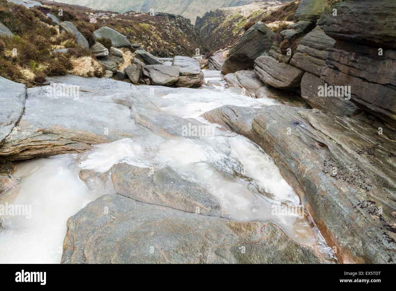 Rock et de glace en hiver. Cours d'eau gelé sur la colline en haut de Grindsbrook Clough sur Kinder Scout, Derbyshire Peak District, England, UK Banque D'Images