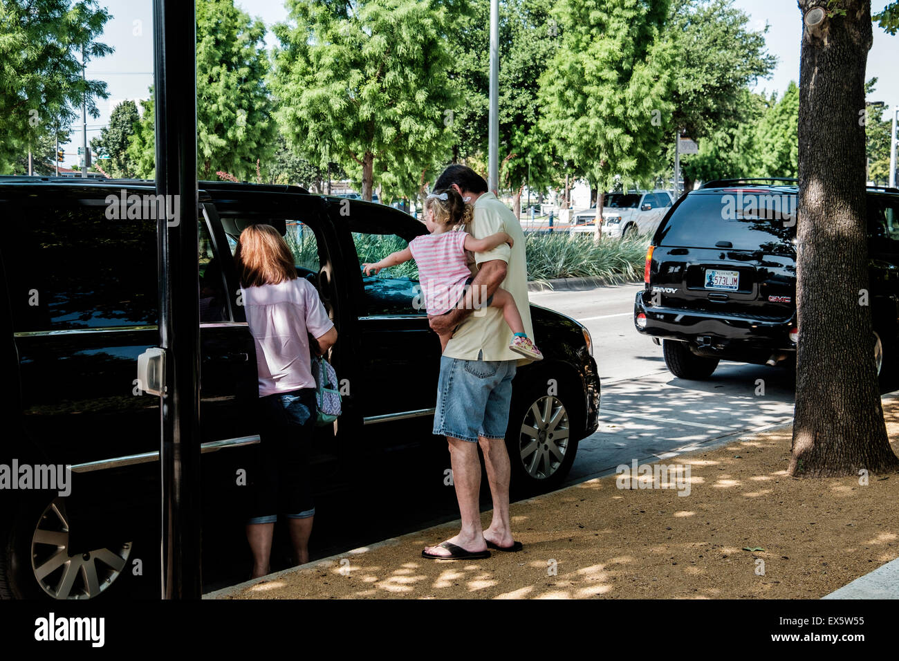 Les parents de charger leurs enfants dans un mini-van stationné à la bordure. Oklahoma City, Oklahoma, USA. Banque D'Images