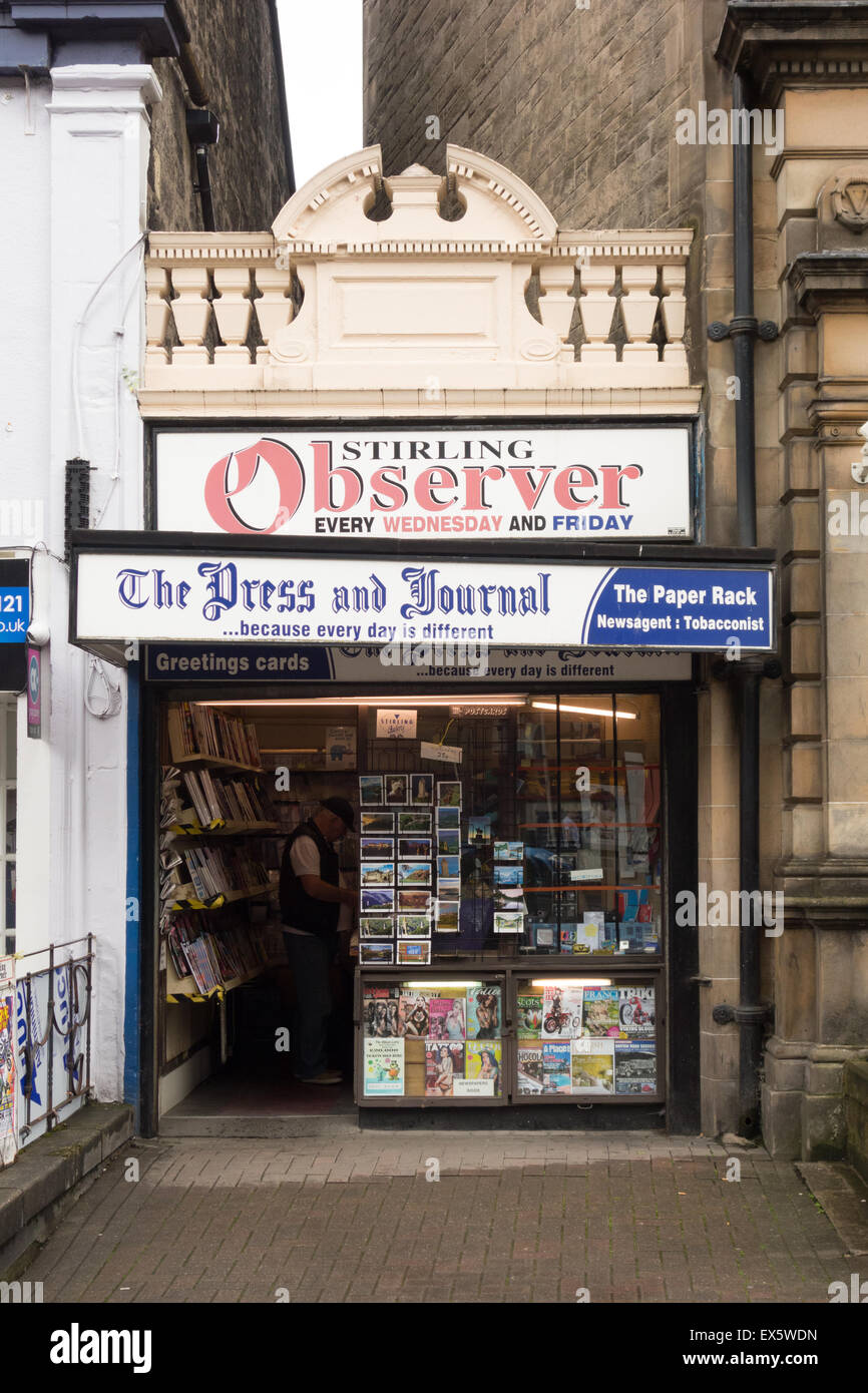 L'achat à l'intérieur de l'homme journal papier Rack, un marchand traditionnel shop à Stirling, Ecosse, Royaume-Uni Banque D'Images