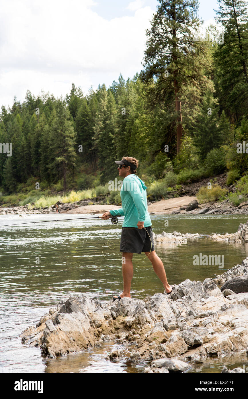 Casting jeunes flyfisherman sa verge dans une rivière du Montana Banque D'Images