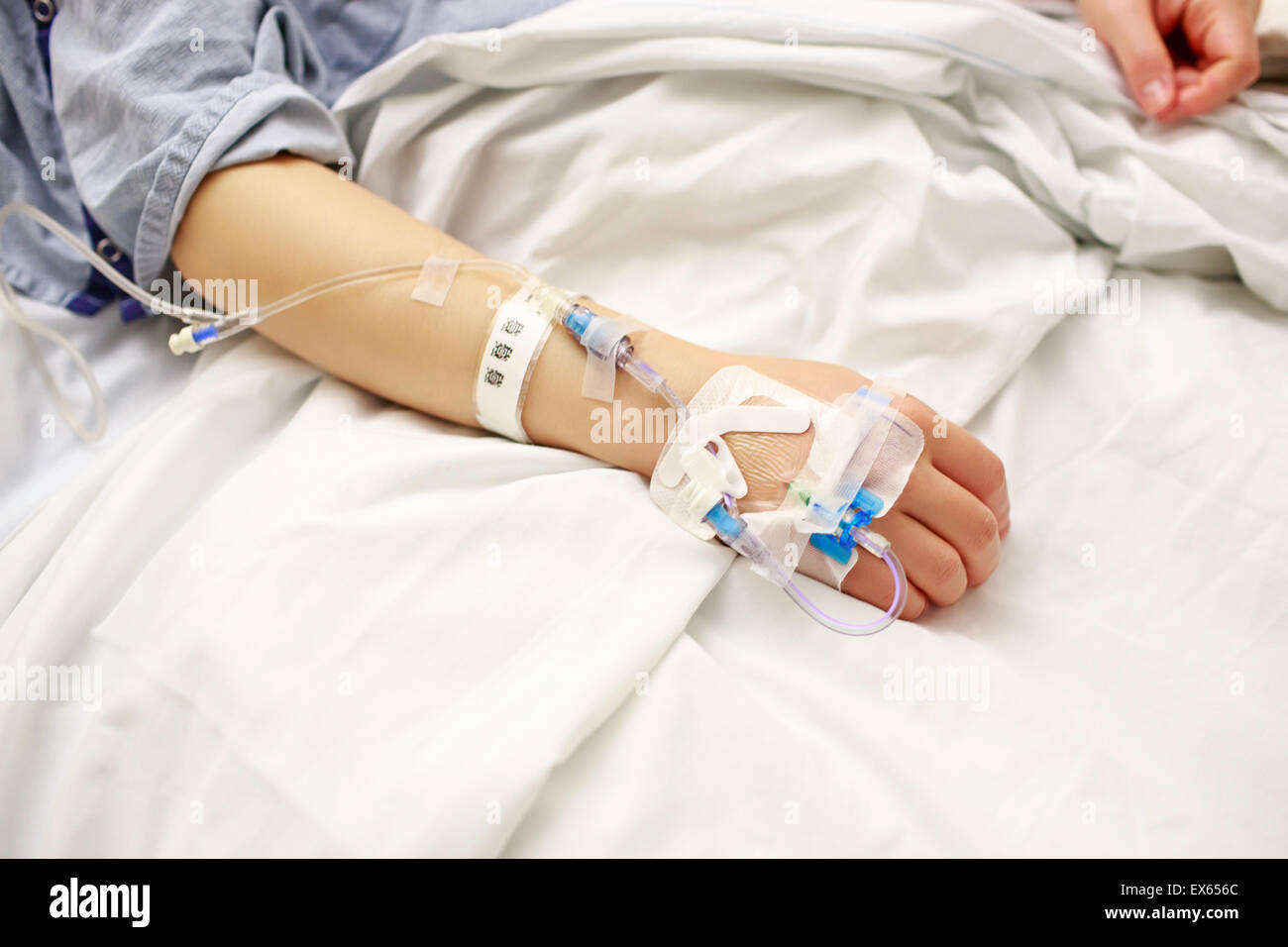 Patient avec les lignes IV couché dans un lit d'hôpital Banque D'Images