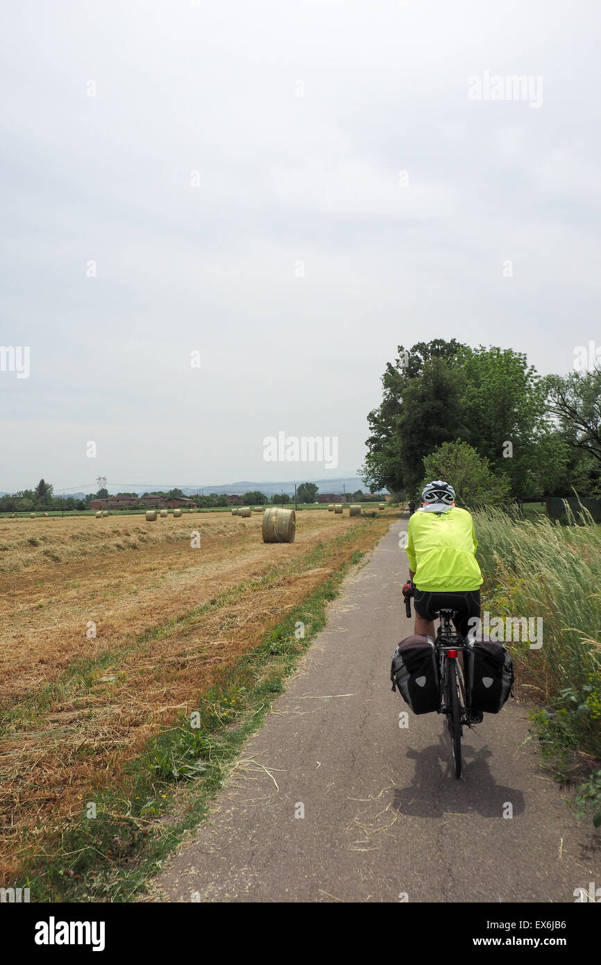 Randonnée vélo cycliste sur une piste cyclable dans la campagne aux côtés de champ de blé récoltés. Banque D'Images