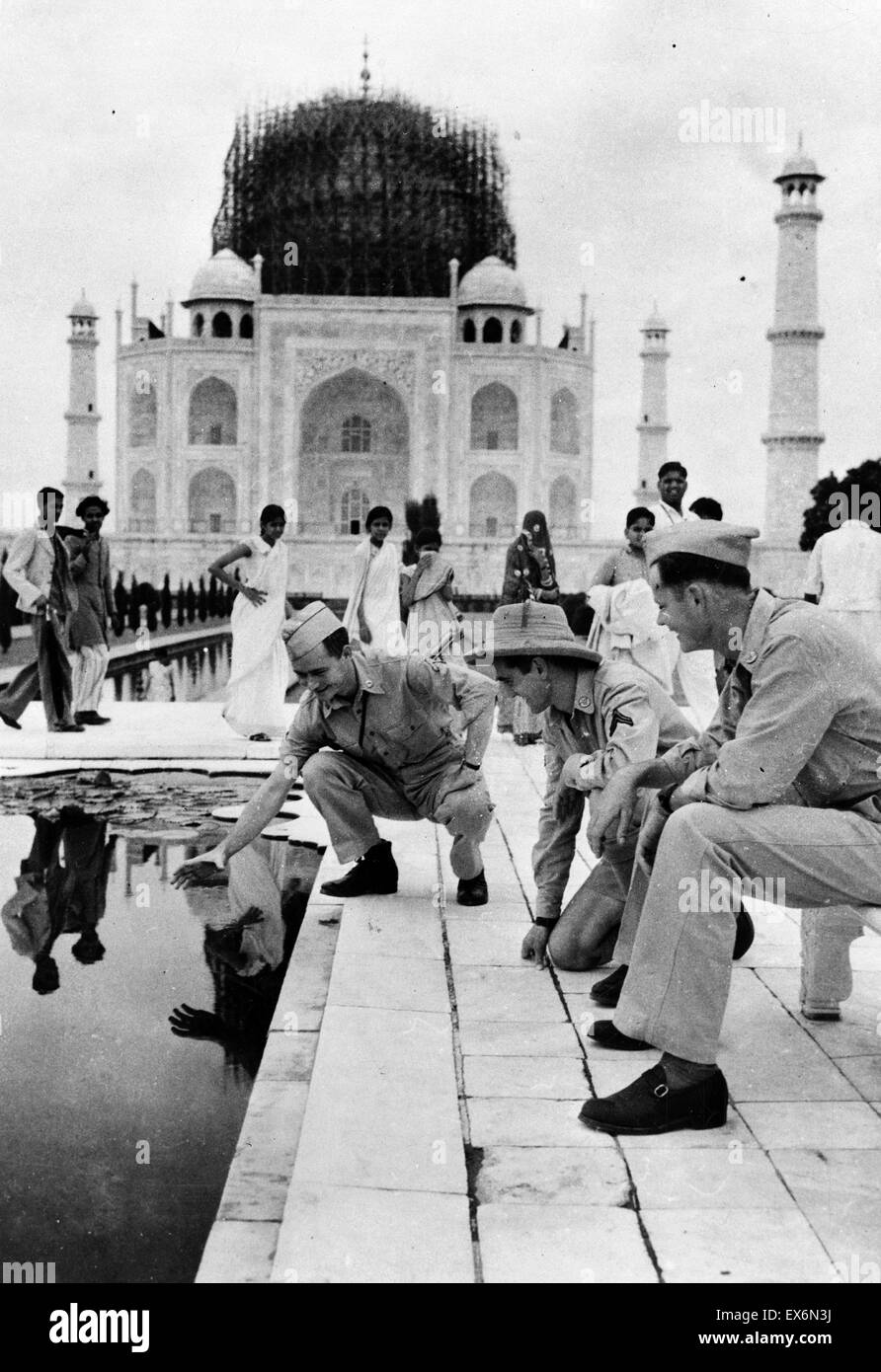 Photographie du Caporal Anthony J. Scopelliti, le soldat de première classe Ray Cherry observant le soldat de première classe C. John Byron, Jr. qui est la pêche dans l'étang à l'extérieur de l'hôtel Taj Mahal. Datée 1942 Banque D'Images