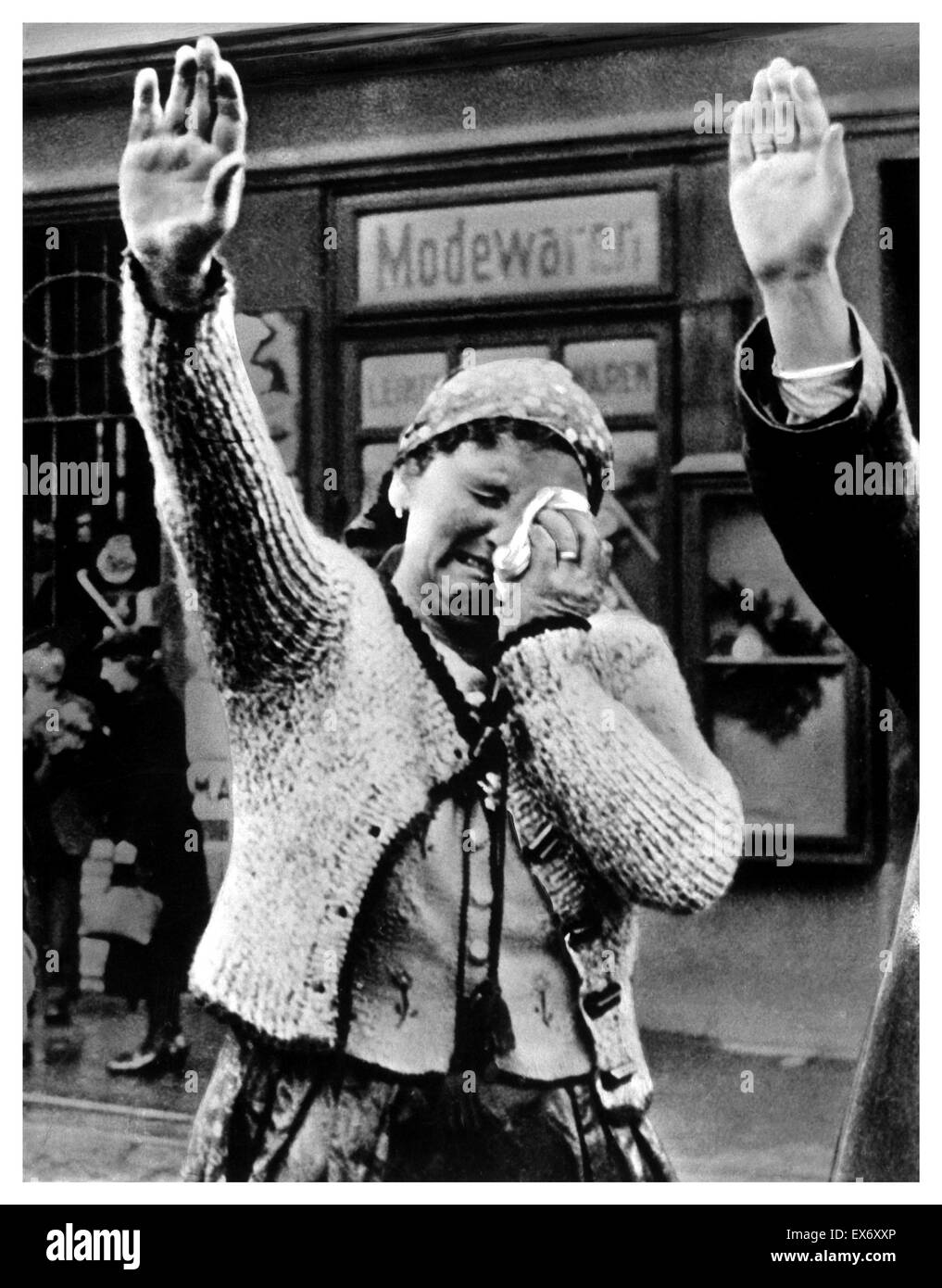 Une femme dans les Sudètes accueille les troupes allemandes avec des larmes et un salut nazi. La Seconde Guerre mondiale. Banque D'Images
