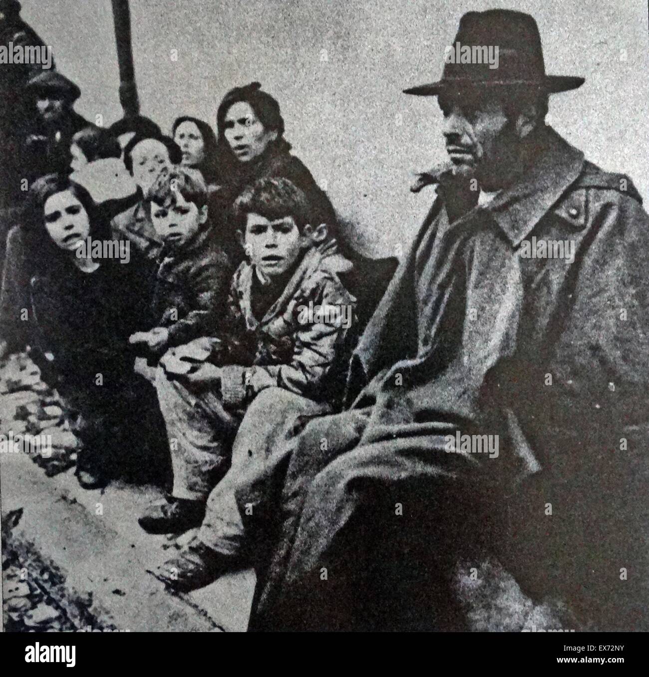 Un groupe de réfugiés épuisés s'asseoir par une route à la phase finale de la guerre civile espagnole Banque D'Images