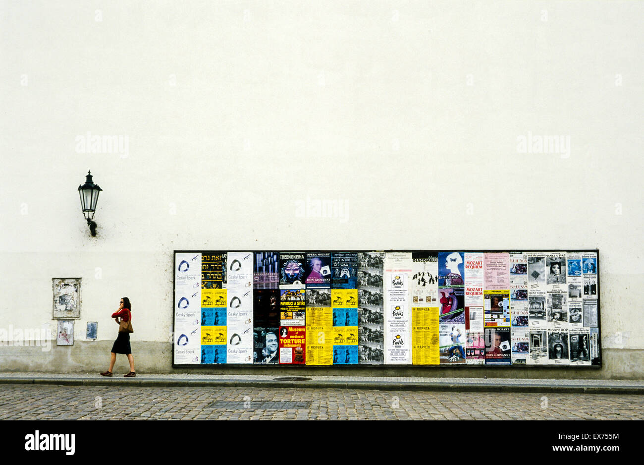 Dame marcher passé billboard alors que sur téléphone mobile, Prague, République tchèque. Banque D'Images