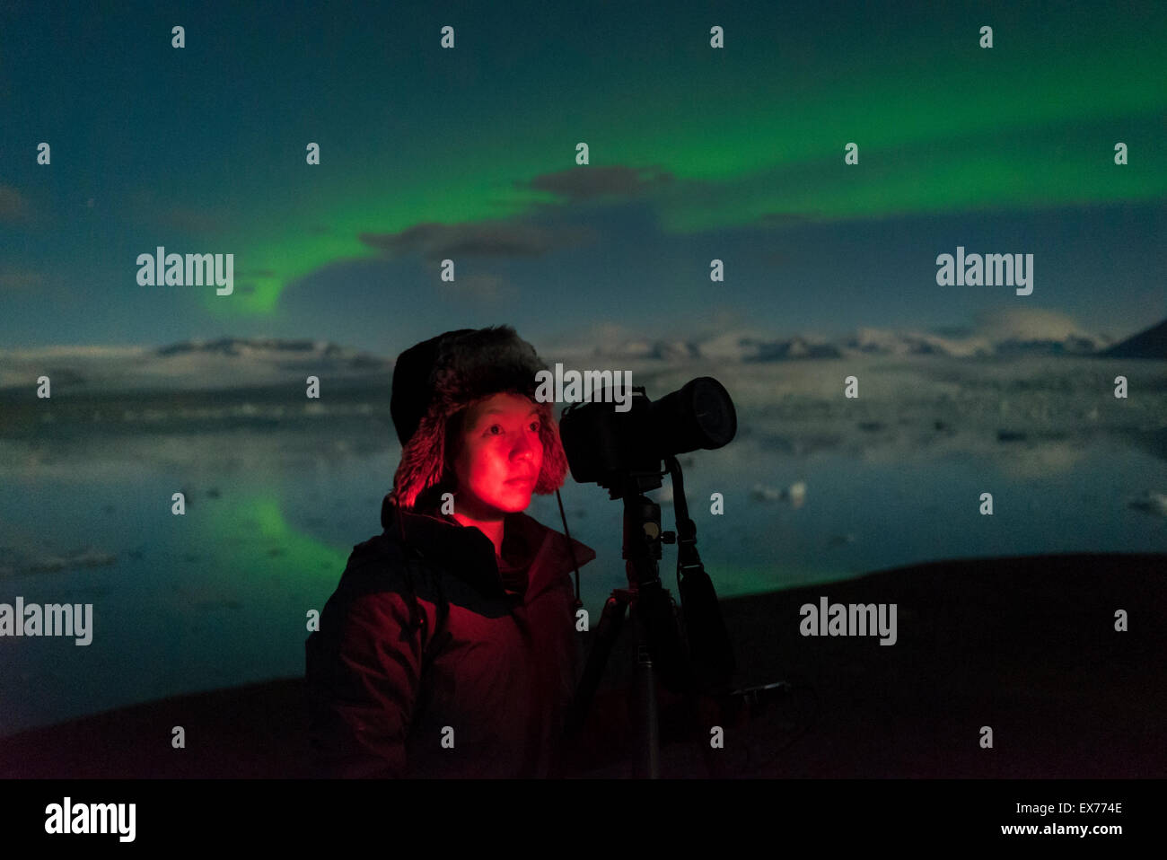 Femme à prendre des photos de l'Aurore boréale au Jokulsarlon Glacial Lagoon, Iceland. Banque D'Images