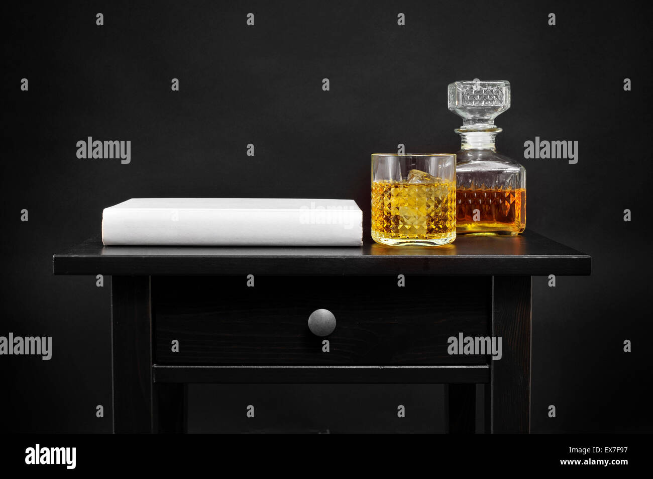 Un livre et une bouteille et un verre d'alcool avec l'échappé belle sur un tableau noir, sur un fond noir Banque D'Images