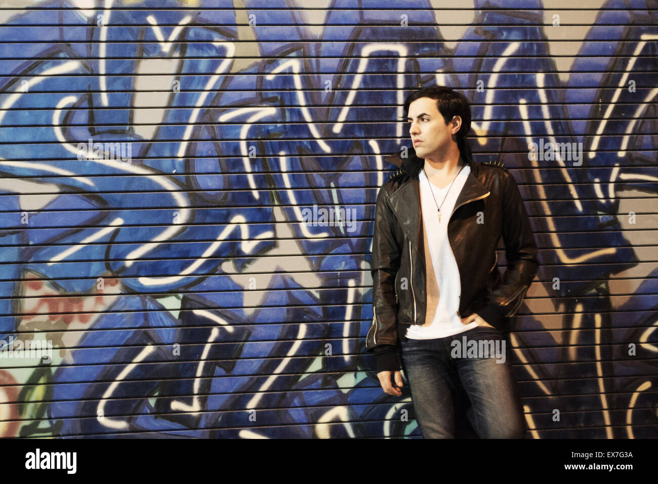 Le modèle Punk pend sur le mur des graffitis de la rue urbaine Banque D'Images