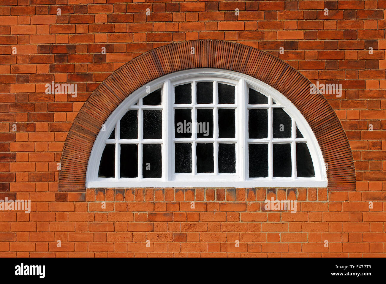 Fenêtre ovale sur un bâtiment moderne en brique rouge. Banque D'Images