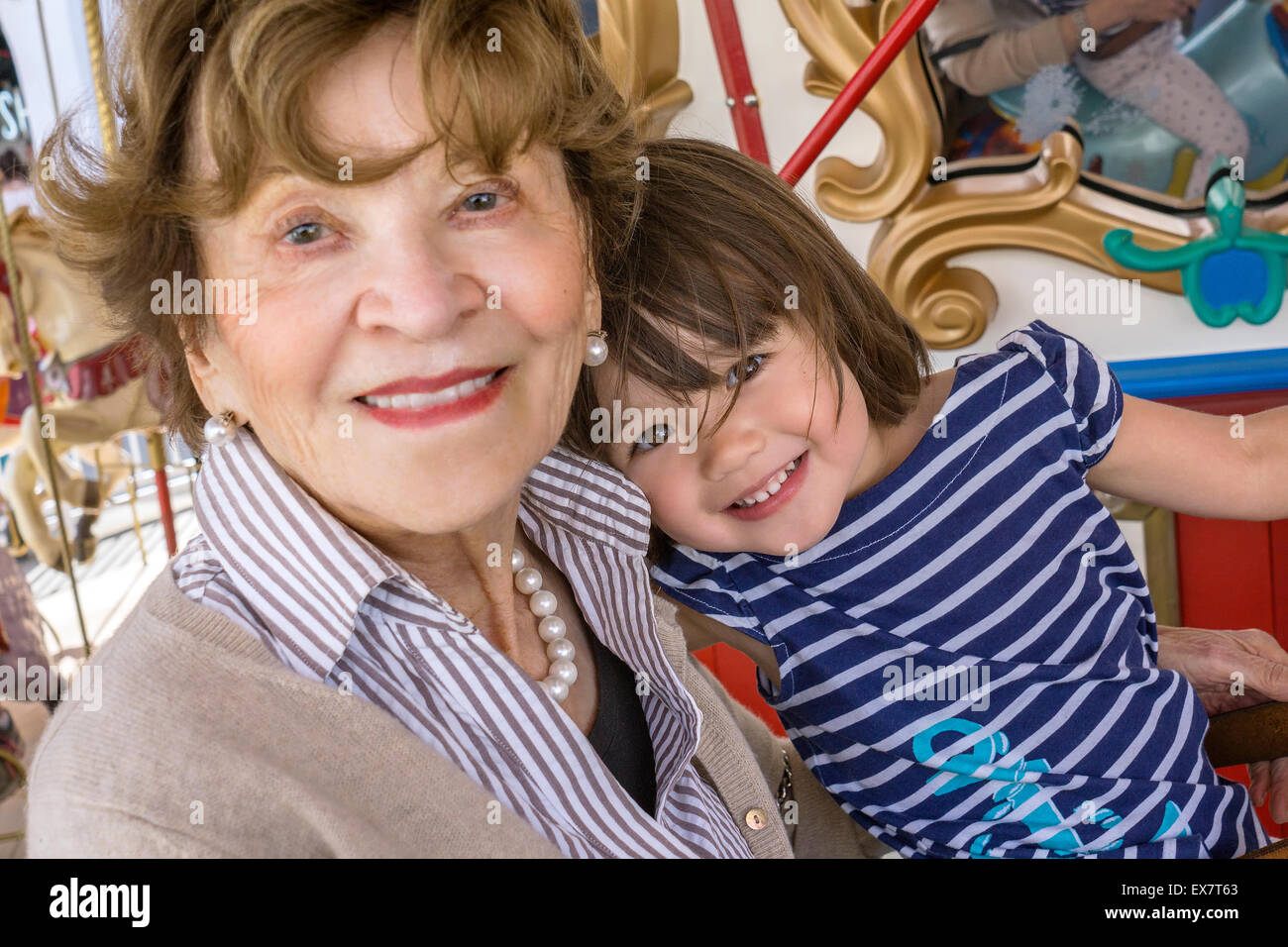 Bébé fille avec son arrière grand-mère au manège, San Diego, Californie Banque D'Images