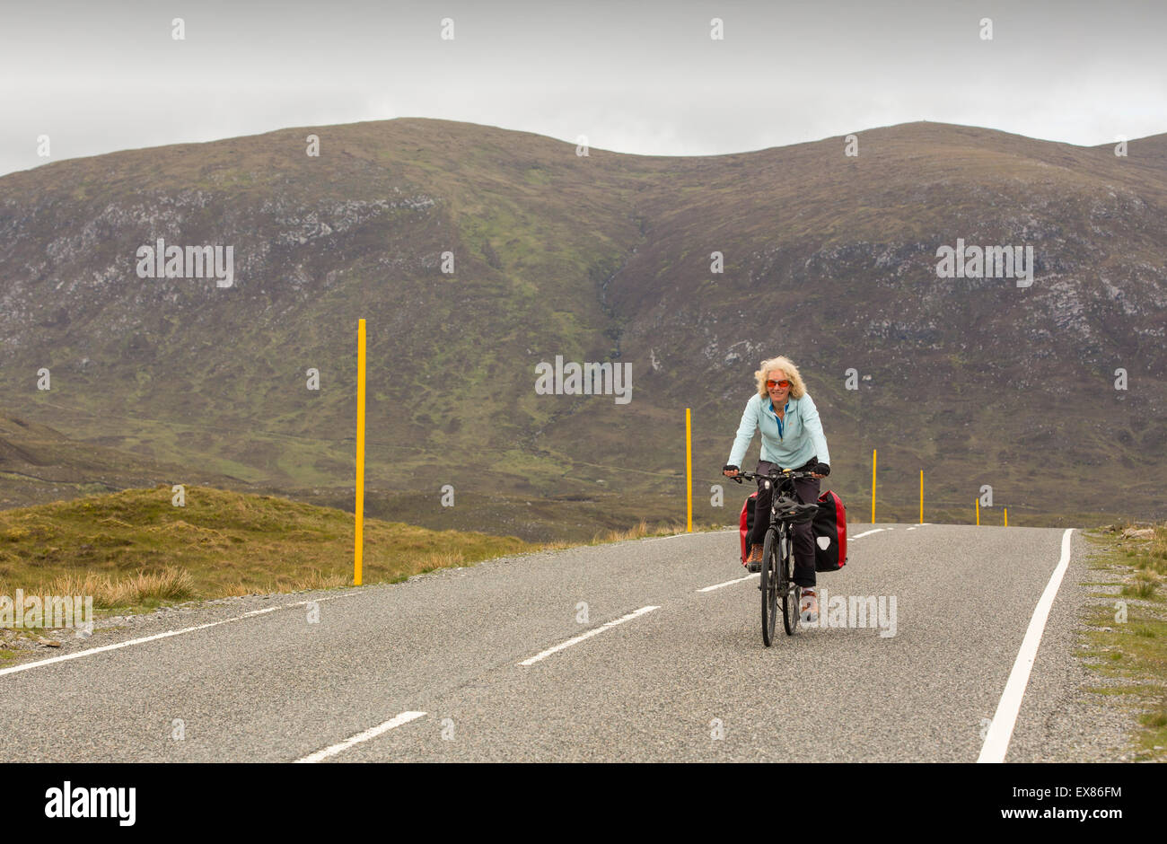 Une femme cyclotourisme sur l'île de Harris, Hébrides extérieures, en Écosse, au Royaume-Uni. Banque D'Images