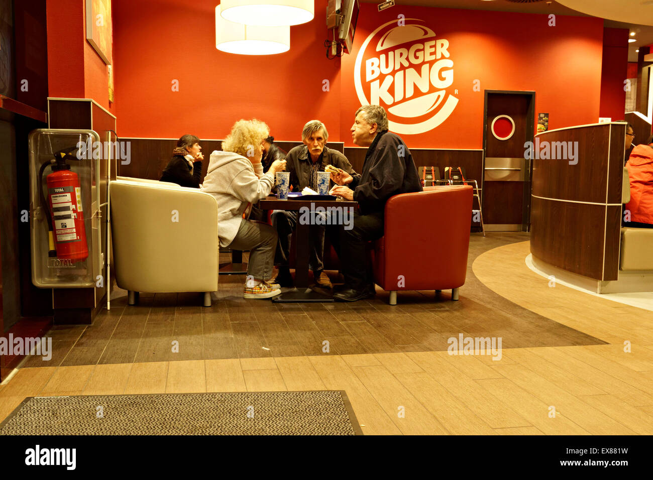 Les personnes âgées la consommation d'aliments dans un restaurant Burger King, Munich, Haute-Bavière, Allemagne. Banque D'Images