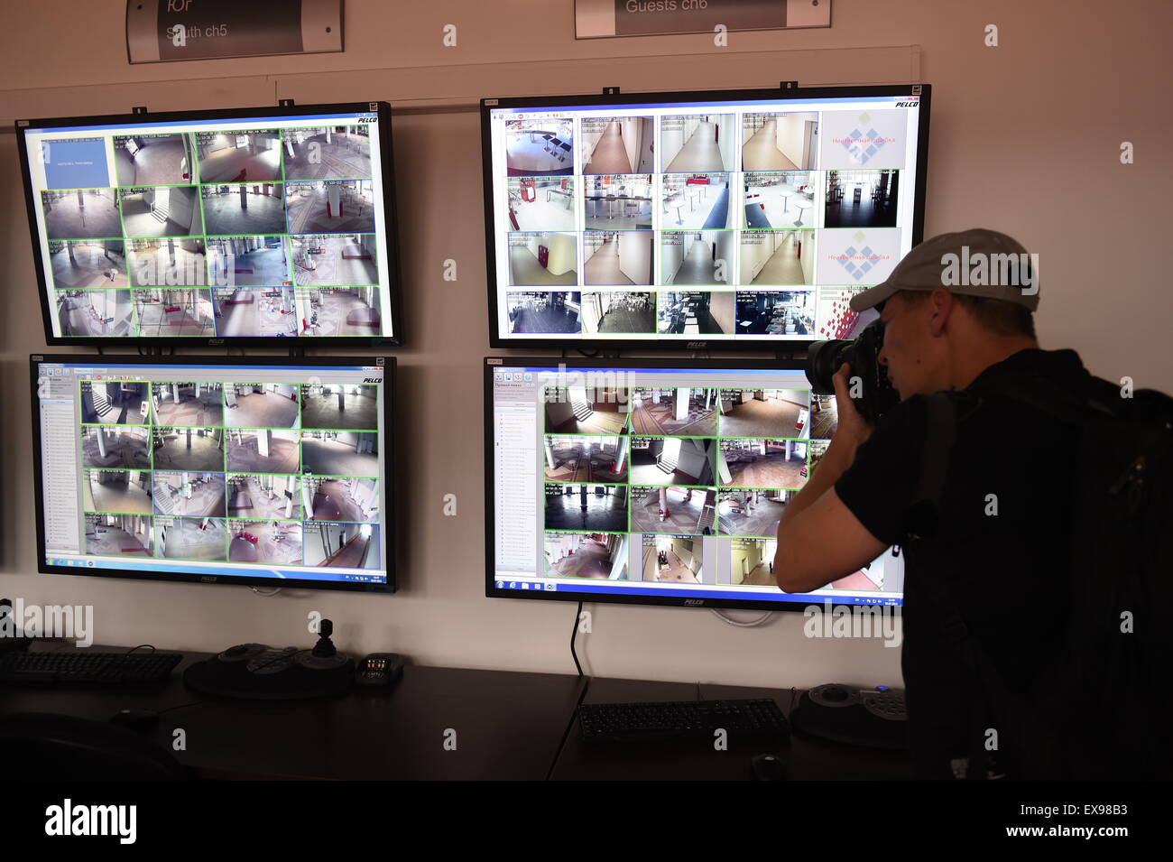 Moscou, Russie. 09 juillet 2015. Un homme prend des photos d'écrans dans le bureau de sécurité qui affichent les images de plusieurs caméras CCTV dans et autour du stade de football du Spartak de Moscou, Russie, le 9 juillet 2015. Le stade de soccer est d'accueillir une partie des matches de la Coupe du Monde FIFA 2018. Photo : Marcus Brandt/dpa/Alamy Live News Banque D'Images