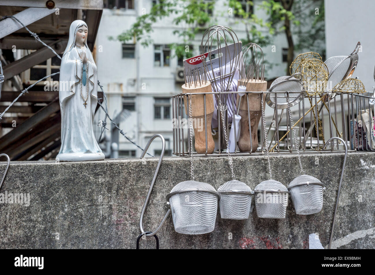 Vierge Marie, statuette à côté des ustensiles de cuisine, dans une rue de Hong Kong Banque D'Images