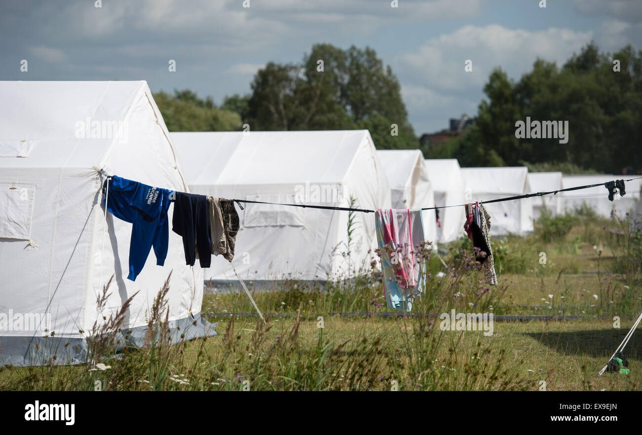 Hamburg-Wilhemsburg, Allemagne. 09 juillet, 2015. Vêtements accrocher sur une clôture en face de tentes, mis en place dans les locaux du centre d'accueil pour les réfugiés, dans Hamburg-Wilhemsburg, Allemagne, 09 juillet 2015. L'état de Hambourg le Parlement débat sur le droit d'asile parmi d'autres sujets le 09 juillet 2015. Photo : DANIEL REINHARDT/dpa/Alamy Live News Banque D'Images