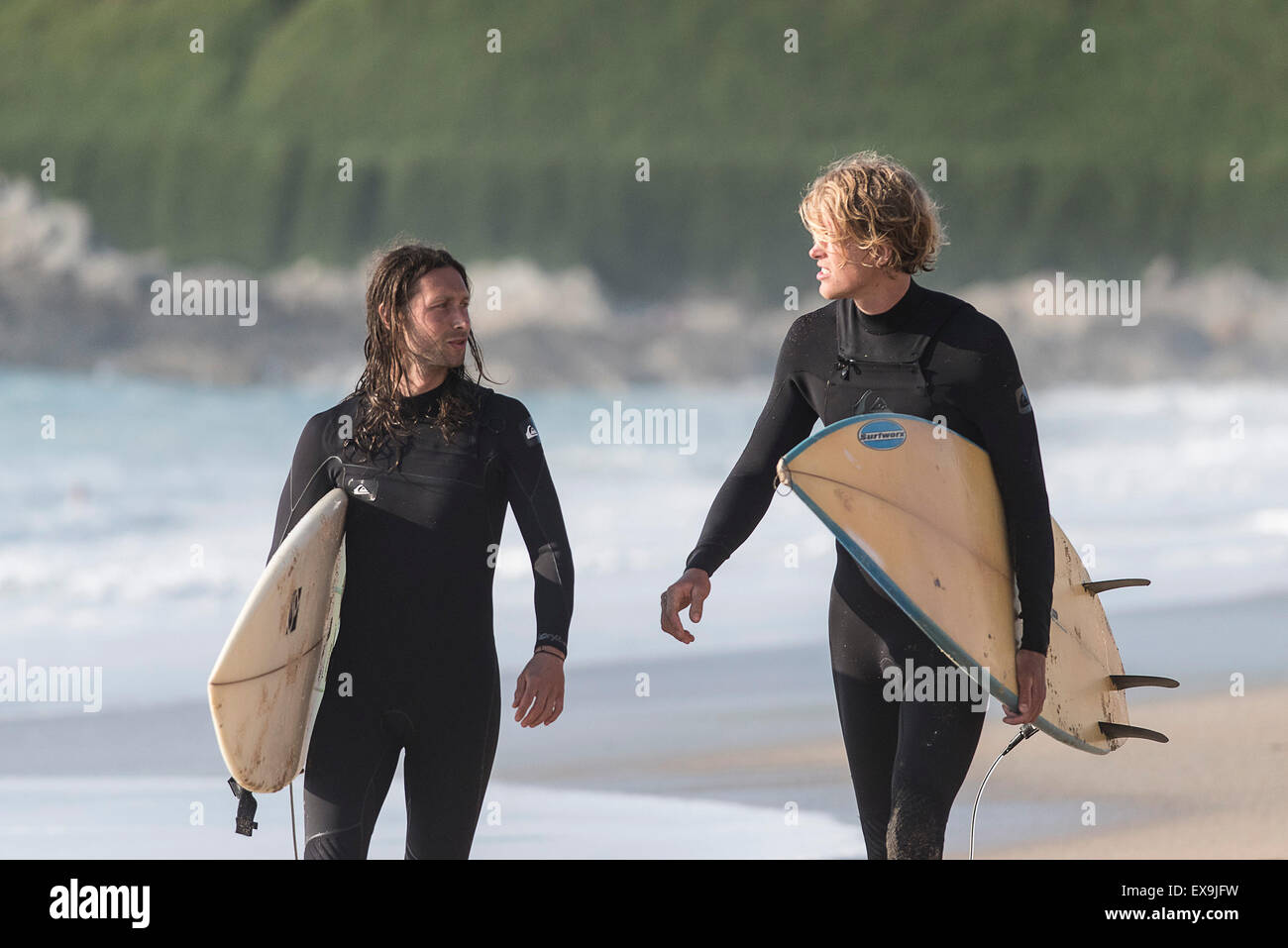 Deux surfeurs en conversation sur la plage de Fistral, Newquay, Cornwall. Banque D'Images