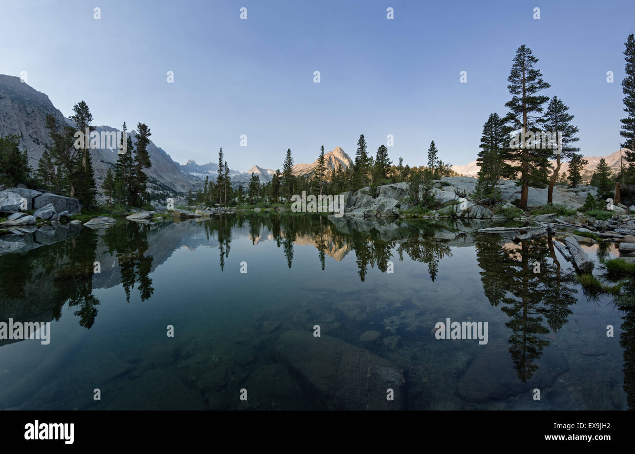 Reflet de la montagnes et les arbres dans le lac bleu dans le matin Banque D'Images