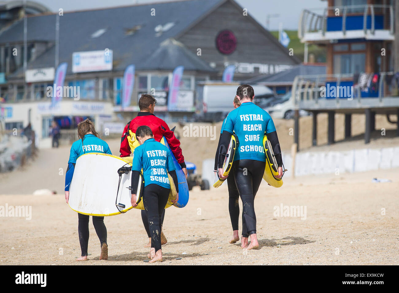 Surfers portent leurs planches sur la plage de Fistral, Newquay, Cornwall. Banque D'Images