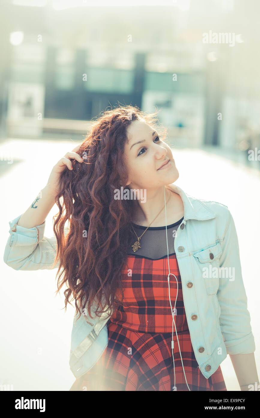 Belle jeune femme hippie avec les cheveux bouclés rouge dans la ville Banque D'Images