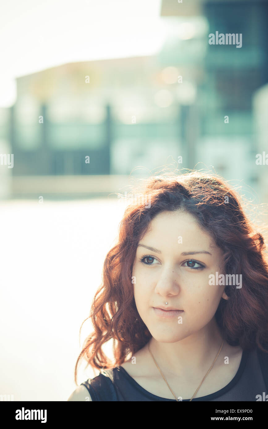 Belle jeune femme hippie avec les cheveux bouclés rouge dans la ville Banque D'Images