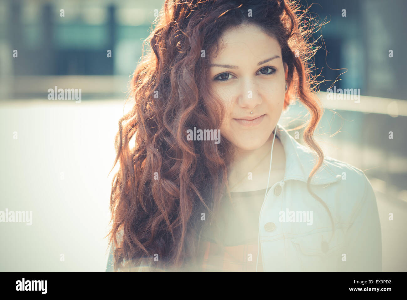 Belle jeune femme hippie avec les cheveux bouclés rouge dans la ville Banque D'Images