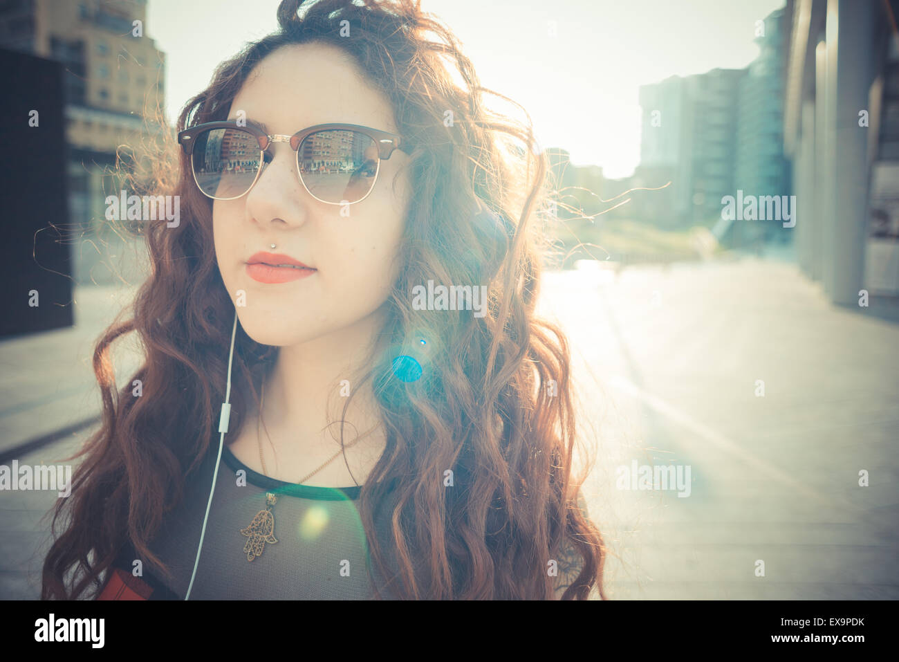 Belle jeune femme hippie avec les cheveux bouclés rouge dans la ville Banque D'Images