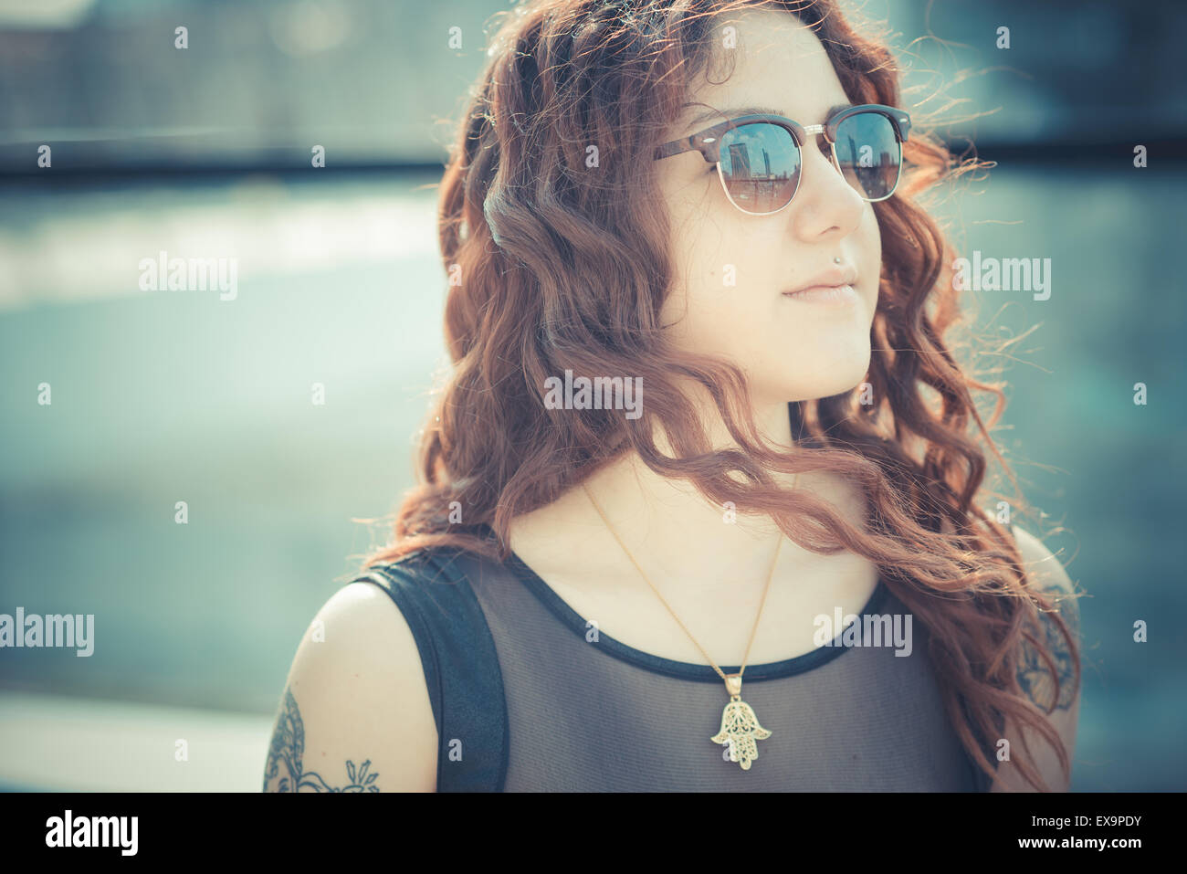 Belle jeune femme hippie avec les cheveux bouclés rouge dans la ville Banque D'Images