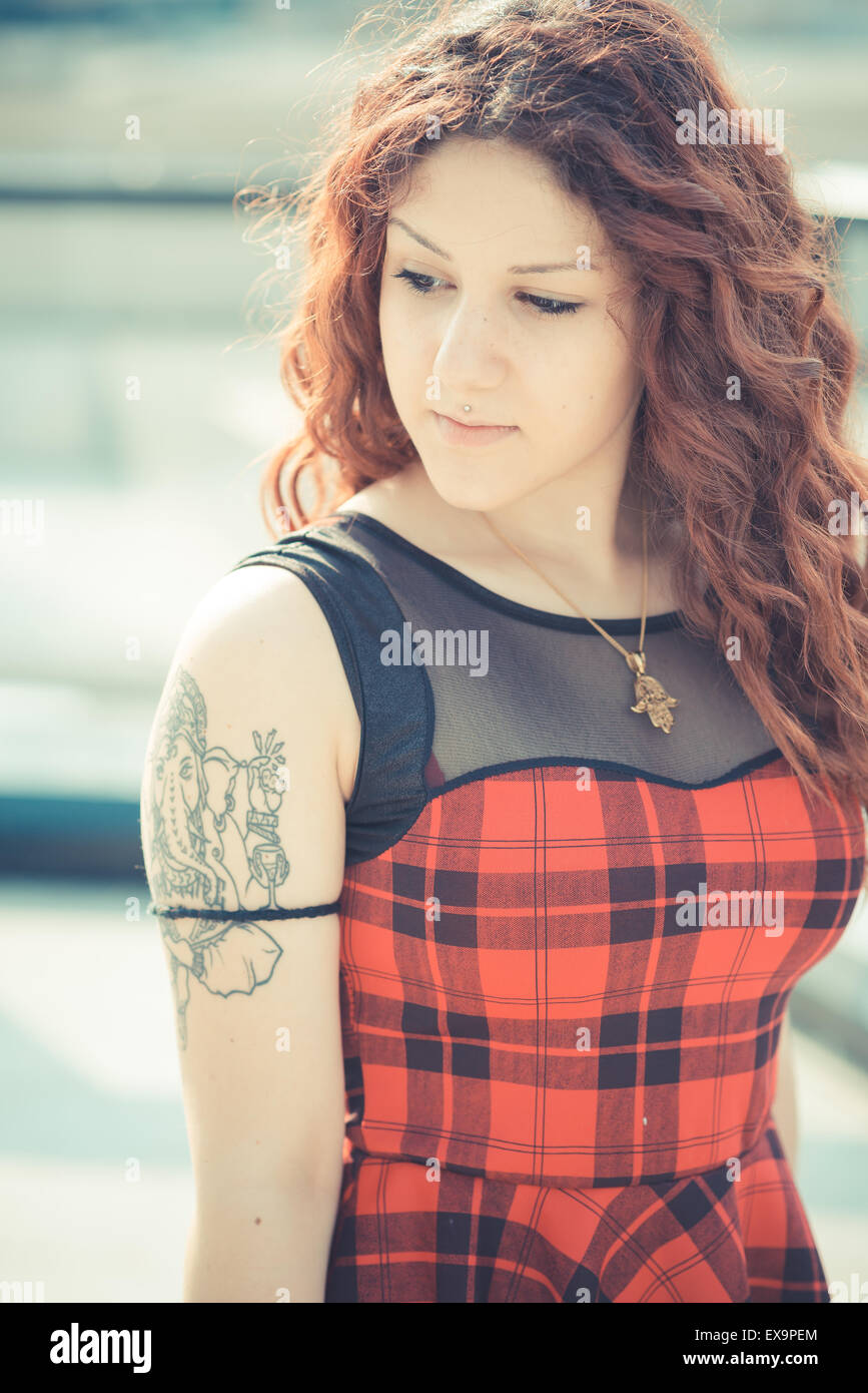Belle jeune femme hippie avec les cheveux bouclés rouge dans la ville Banque D'Images
