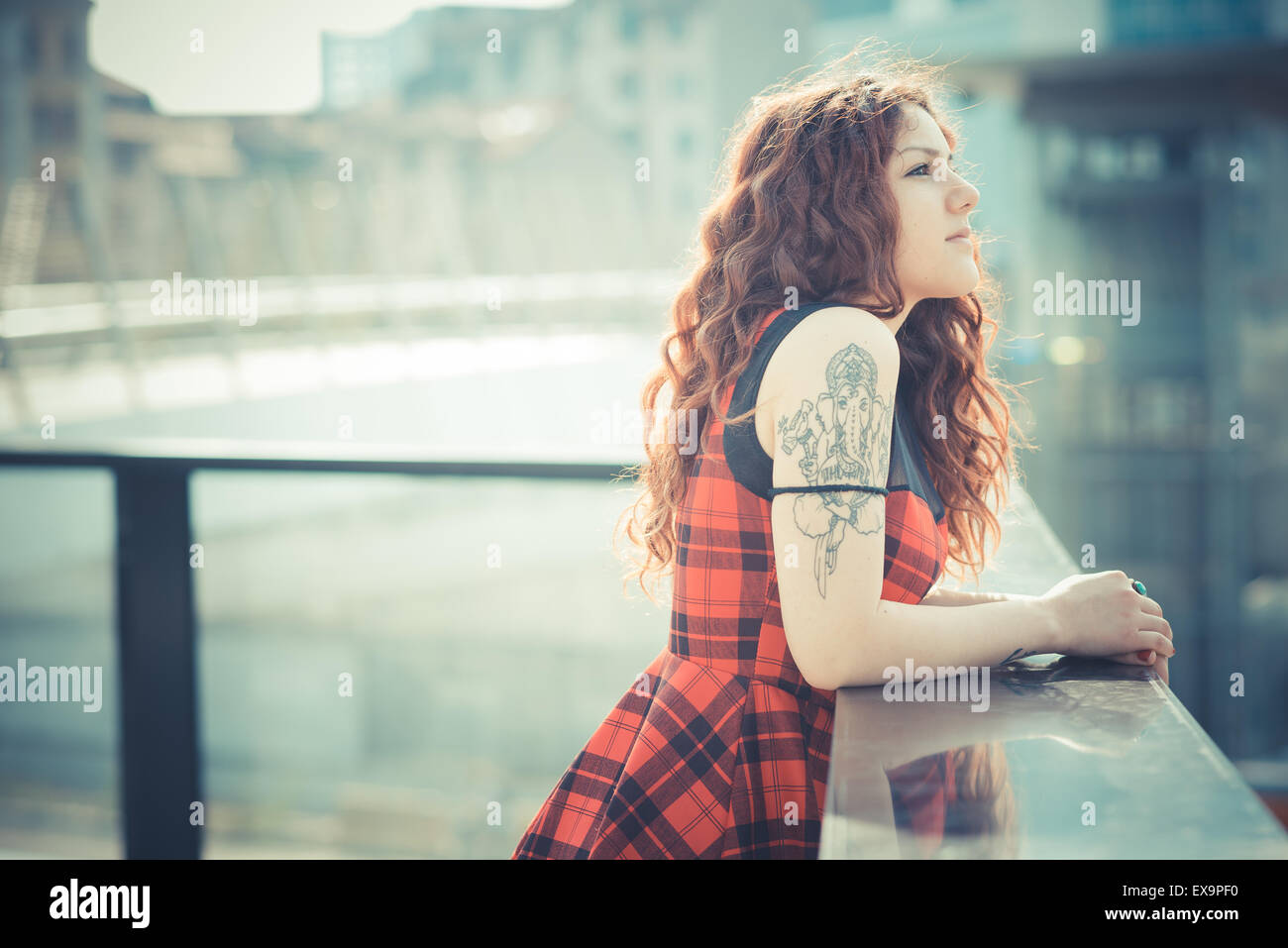 Belle jeune femme hippie avec les cheveux bouclés rouge dans la ville Banque D'Images