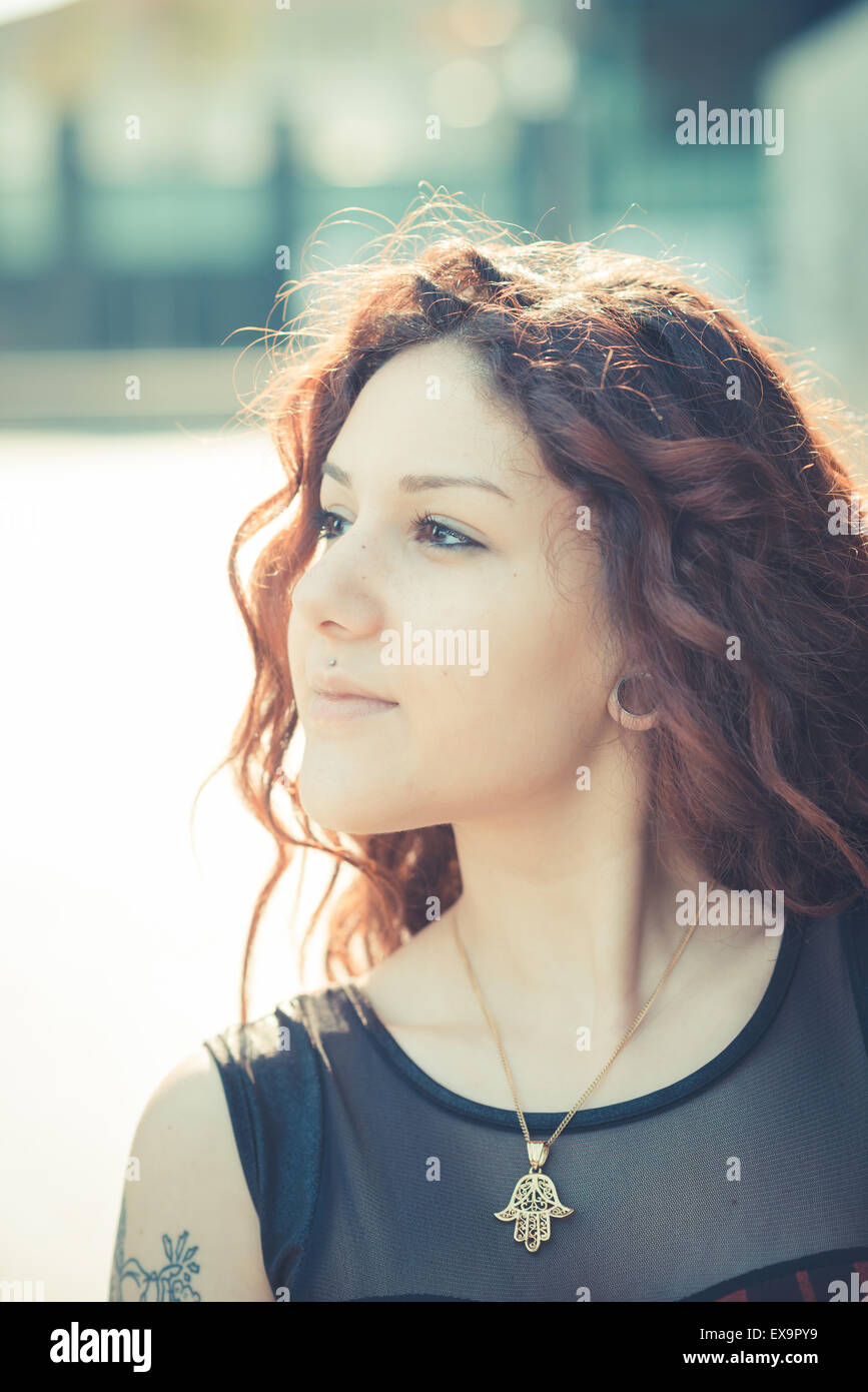 Belle jeune femme hippie avec les cheveux bouclés rouge dans la ville Banque D'Images