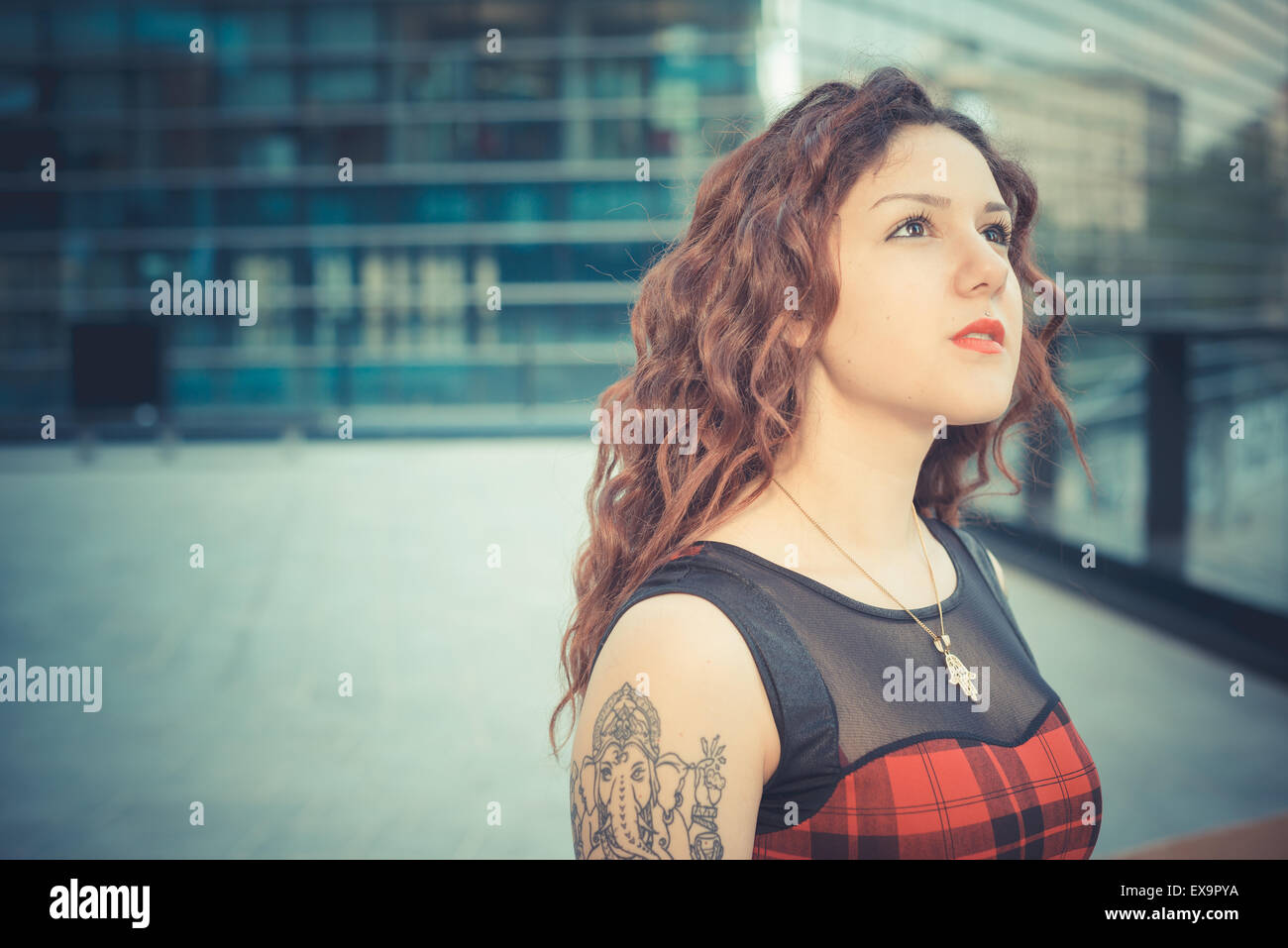 Belle jeune femme hippie avec les cheveux bouclés rouge dans la ville Banque D'Images