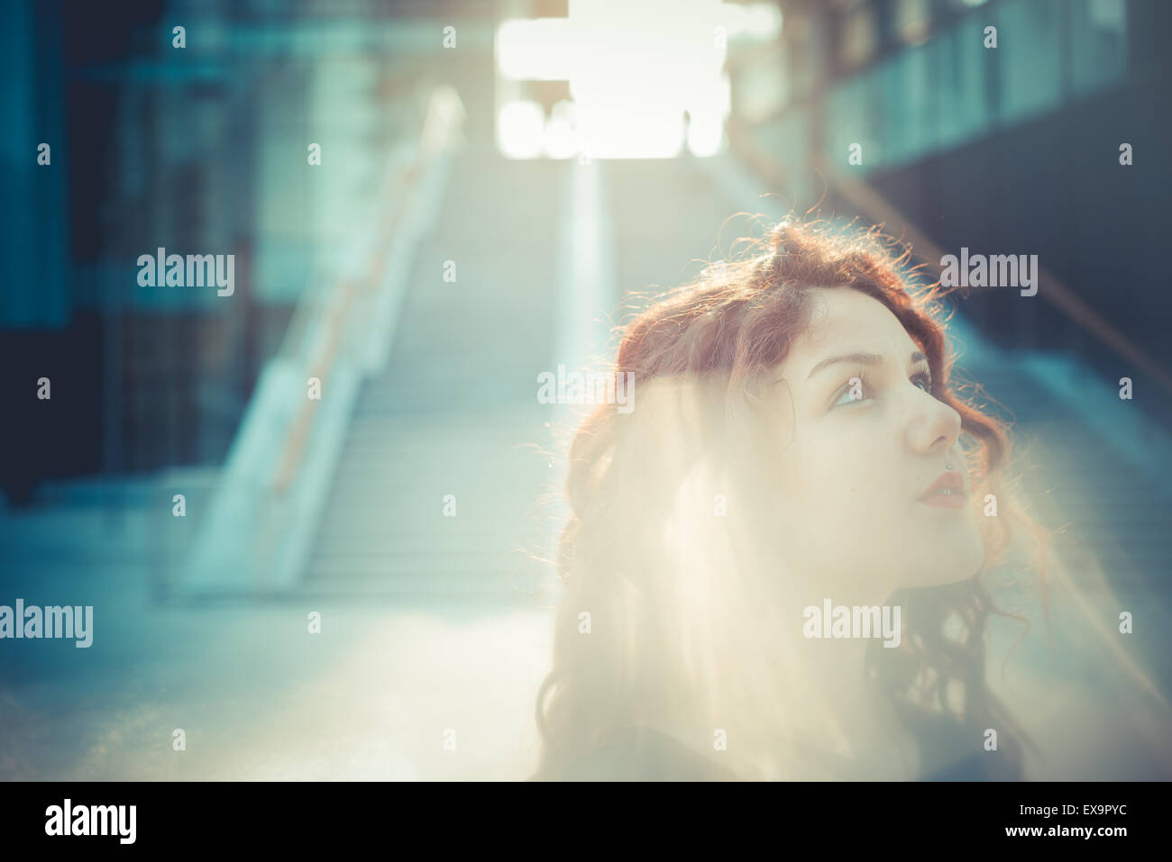 Belle jeune femme hippie avec les cheveux bouclés rouge dans la ville Banque D'Images