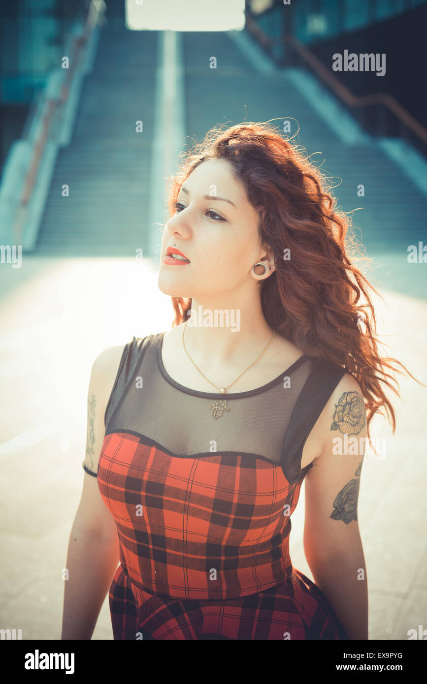 Belle jeune femme hippie avec les cheveux bouclés rouge dans la ville Banque D'Images