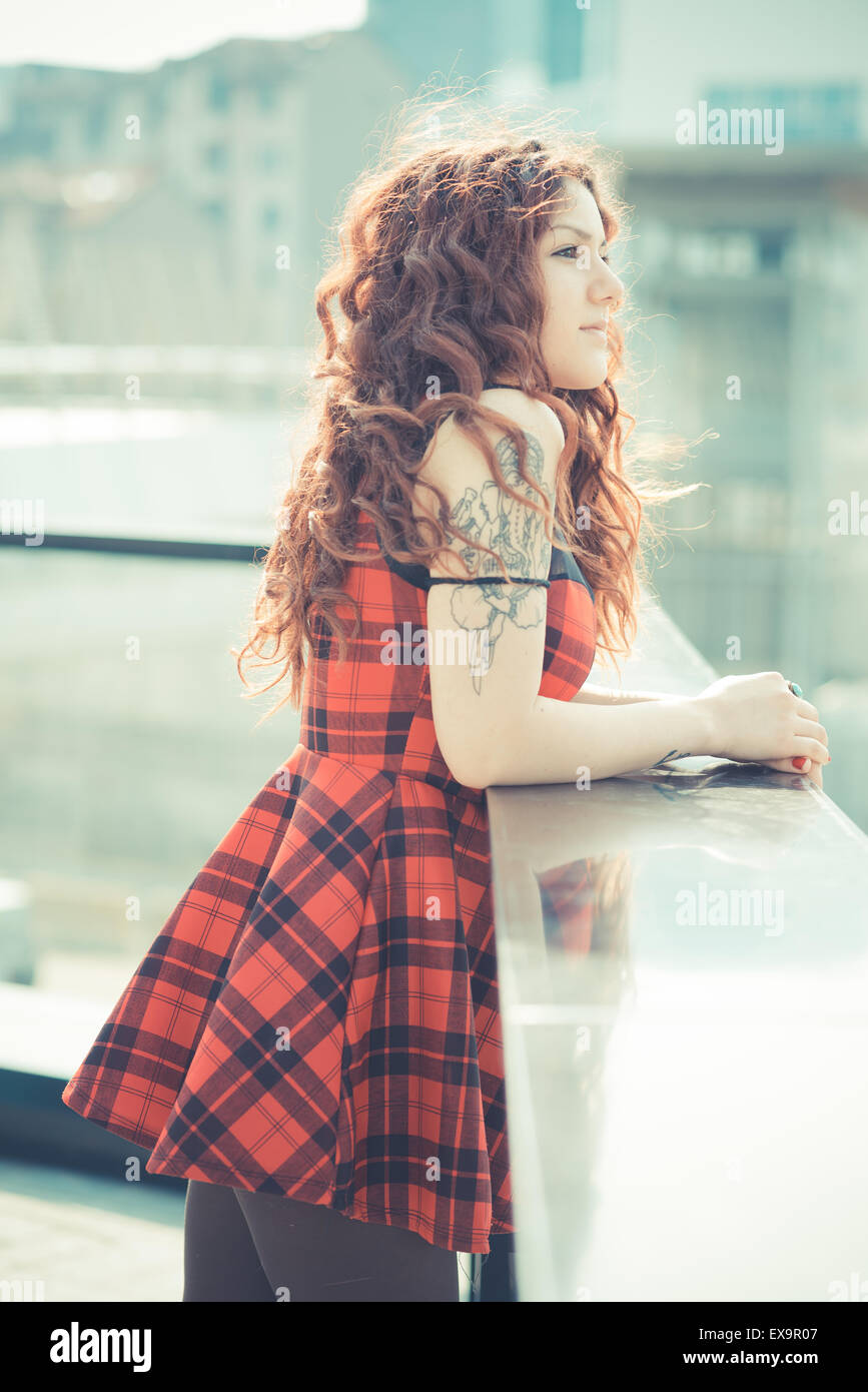 Belle jeune femme hippie avec les cheveux bouclés rouge dans la ville Banque D'Images