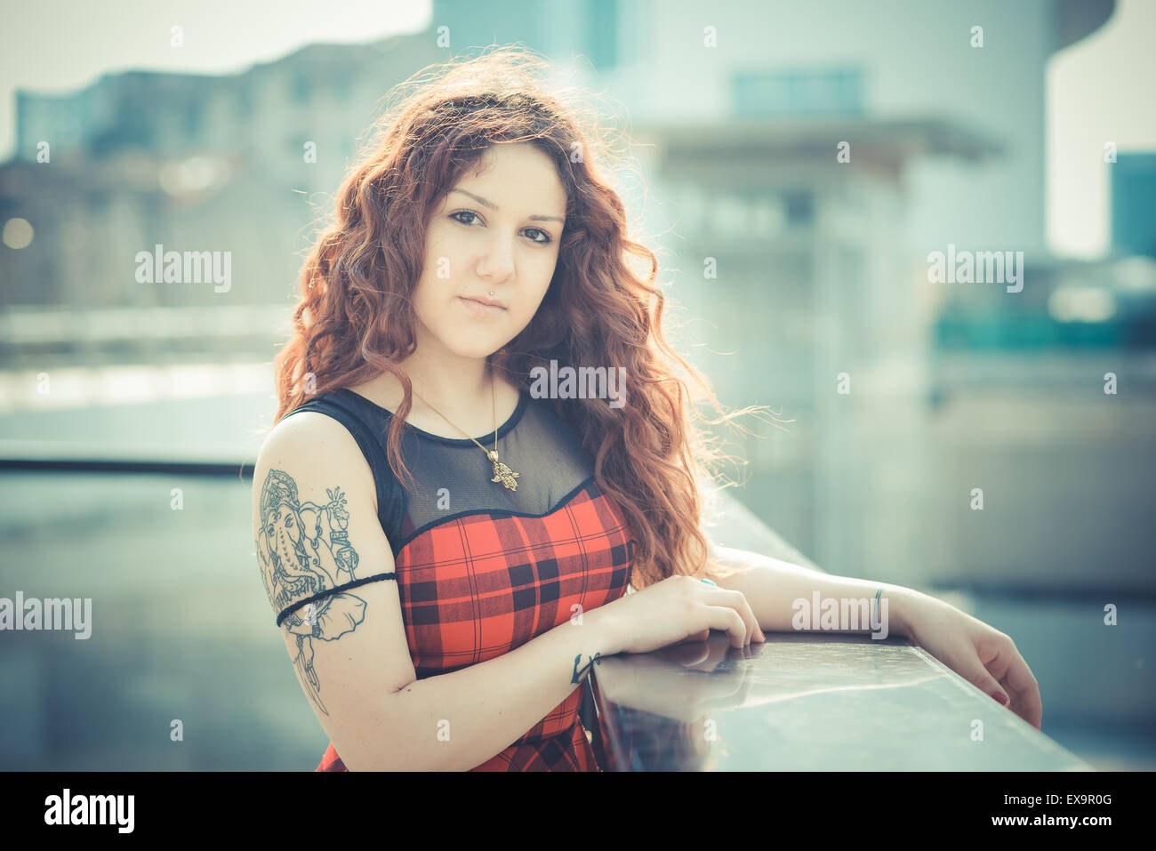 Belle jeune femme hippie avec les cheveux bouclés rouge dans la ville Banque D'Images