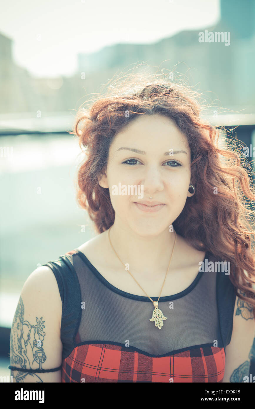 Belle jeune femme hippie avec les cheveux bouclés rouge dans la ville Banque D'Images