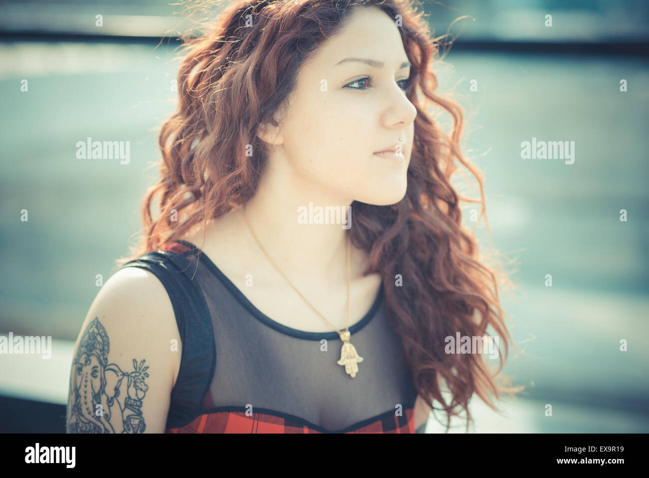 Belle jeune femme hippie avec les cheveux bouclés rouge dans la ville Banque D'Images