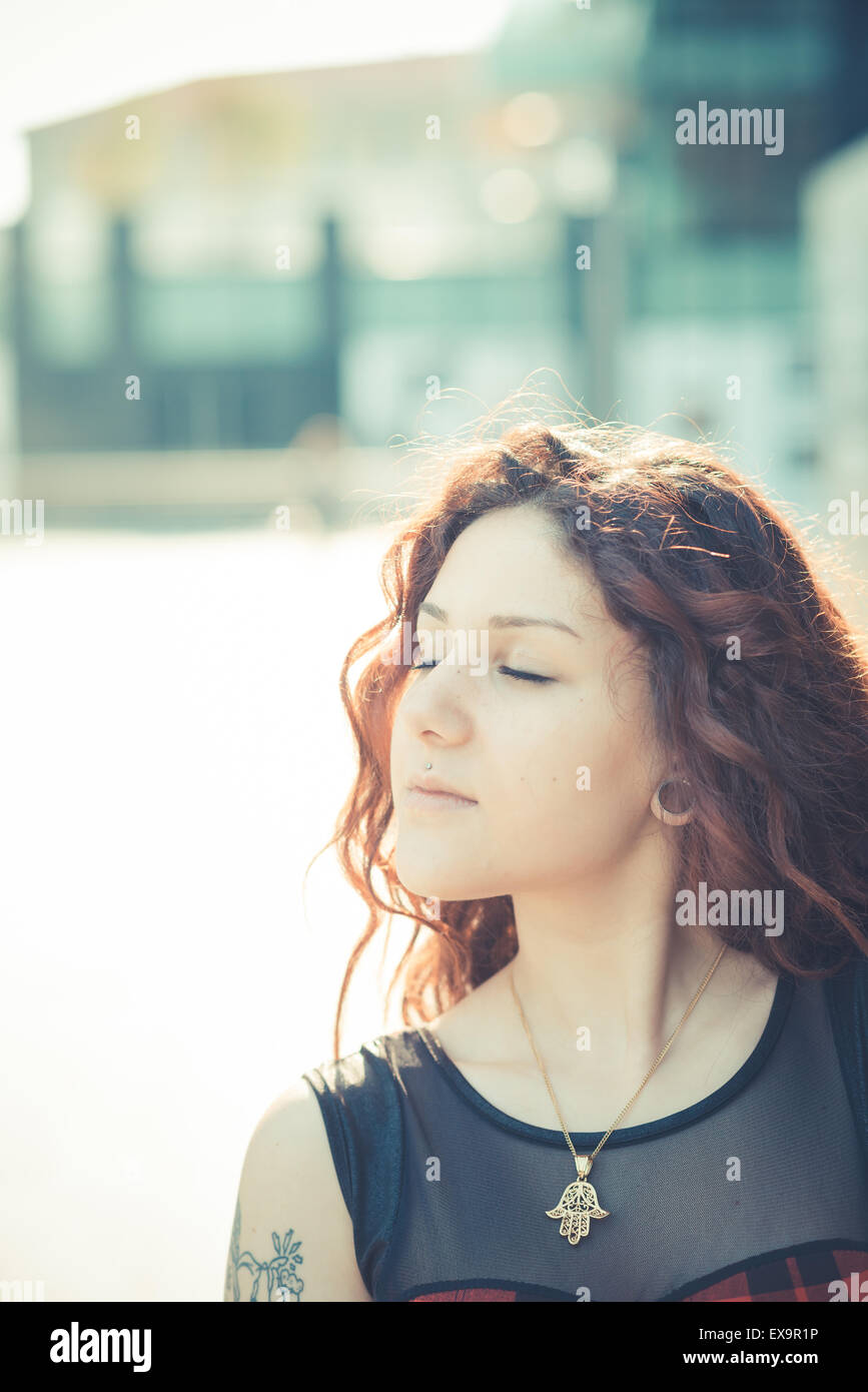 Belle jeune femme hippie avec les cheveux bouclés rouge dans la ville Banque D'Images