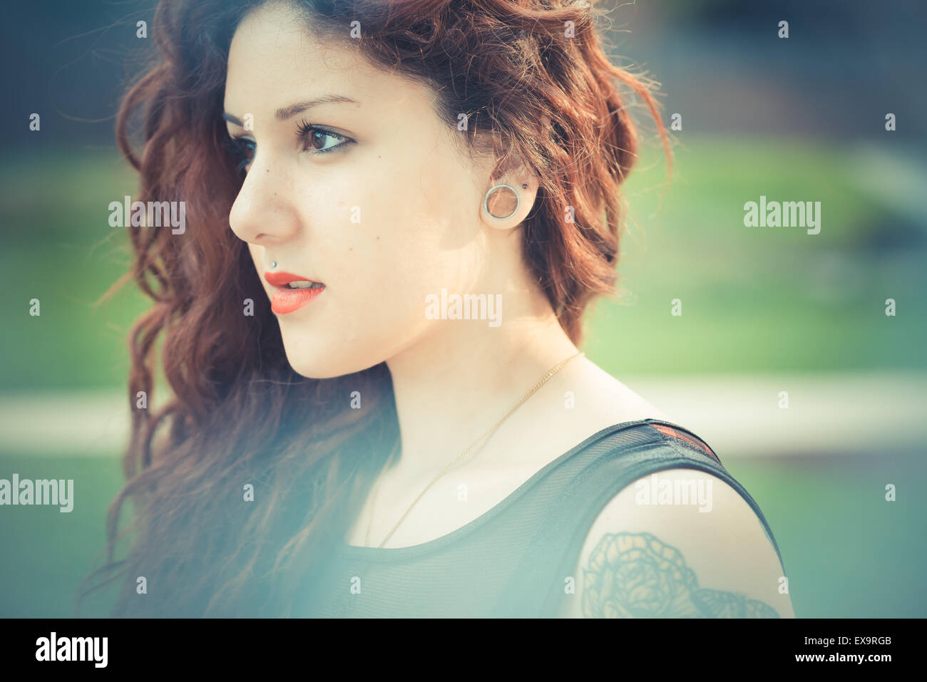 Belle jeune femme hippie avec les cheveux bouclés rouge dans la ville Banque D'Images