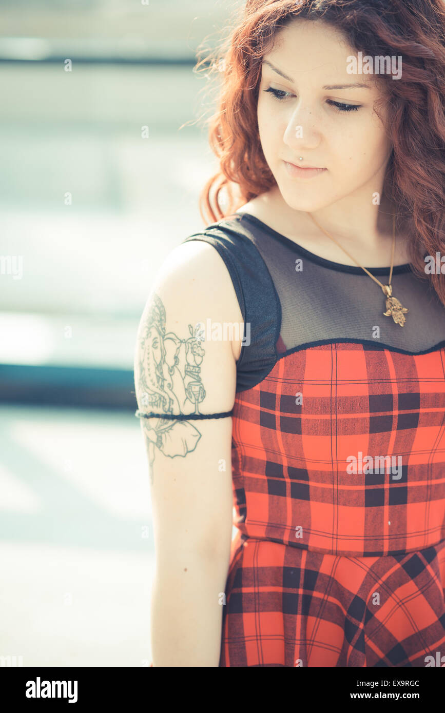 Belle jeune femme hippie avec les cheveux bouclés rouge dans la ville Banque D'Images