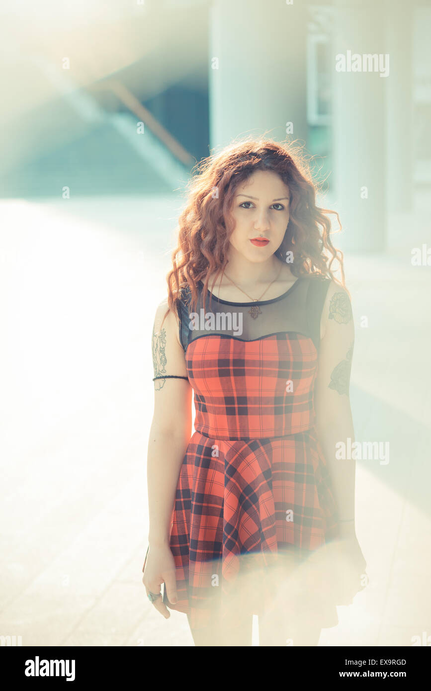 Belle jeune femme hippie avec les cheveux bouclés rouge dans la ville Banque D'Images