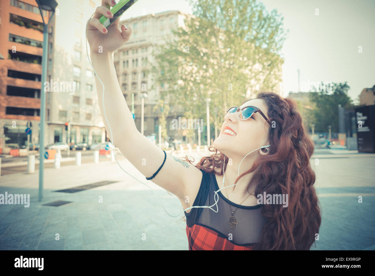 Belle jeune femme hippie avec les cheveux bouclés rouge dans la ville Banque D'Images