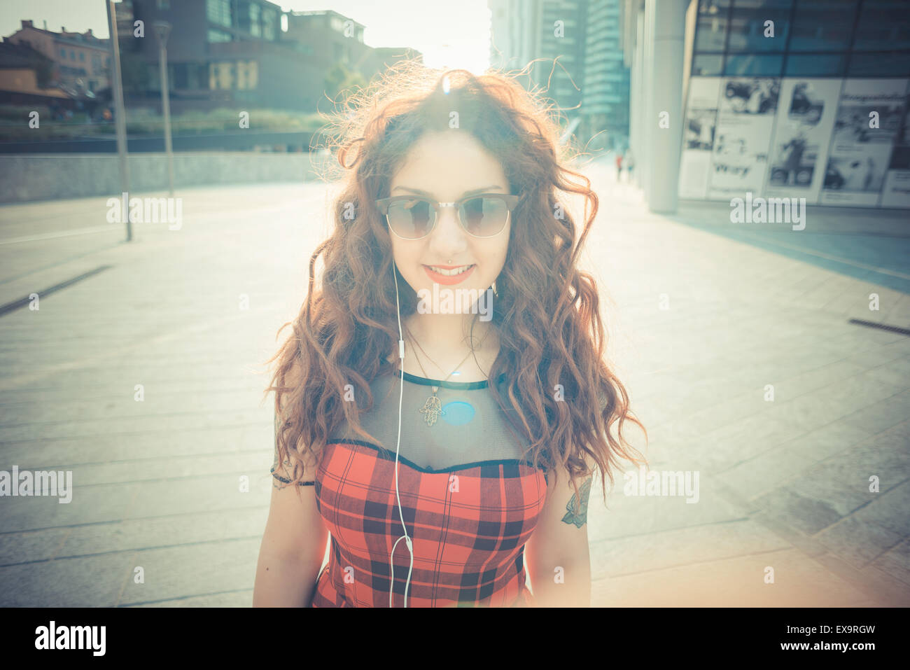 Belle jeune femme hippie avec les cheveux bouclés rouge dans la ville Banque D'Images